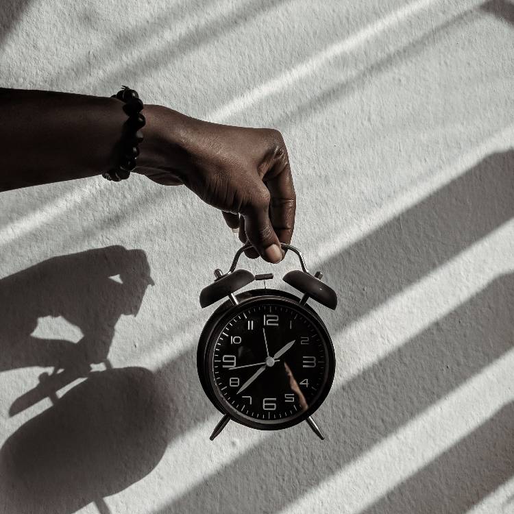 Be-Patient hand holding a clock