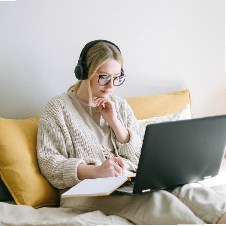 Woman on bed doing research on a computer